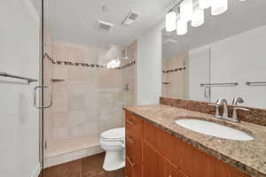 Bathroom with a stall shower, vanity, and tile patterned floors