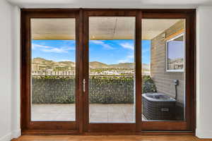 Doorway to outside with a mountain view and wood finished floors