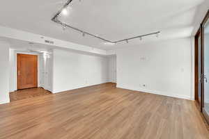 Spare room featuring rail lighting and light wood finished floors