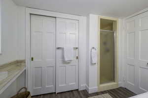 Full bath with a stall shower and wood finished floors