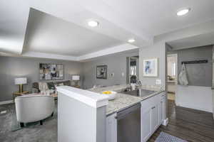 Kitchen featuring dishwasher, open floor plan, white cabinetry, recessed lighting, and a peninsula