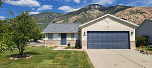 Single story home with a mountain view, a front yard
