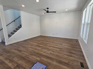 Unfurnished living room featuring ceiling fan, dark wood-type flooring, stairs, and recessed lighting