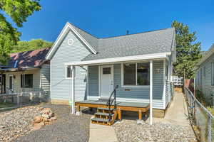 View of front facade featuring a shingled roof and new front porch and deck