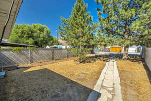 View of partially fenced backyard and 2 dedicated parking spaces