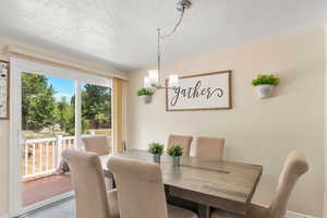 Dining space featuring a textured ceiling and a chandelier