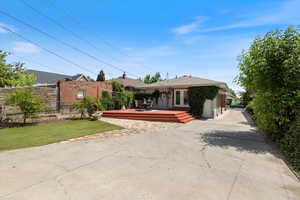 View of front of home with a deck and concrete driveway