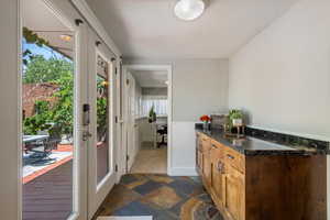 Kitchen with dark stone finish floors, a peninsula, wainscoting, and dark stone counters