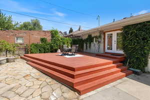 Wooden terrace featuring french doors and outdoor dining space