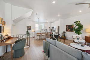 Living area with light wood-style flooring, a ceiling fan, and recessed lighting