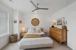 Bedroom featuring light colored carpet, a ceiling fan, multiple windows, and recessed lighting