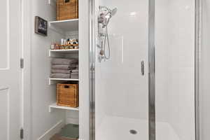 Bathroom with a stall shower and baseboards