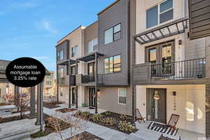 View of front of house featuring stucco siding and a balcony
