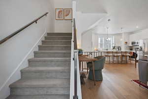 Stairs featuring wood finished floors and recessed lighting
