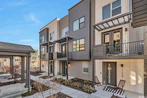 View of front of house featuring a balcony, stucco siding, and a residential view