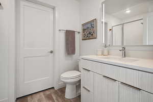 Full bath with wood finished floors, vanity, an enclosed shower, and recessed lighting