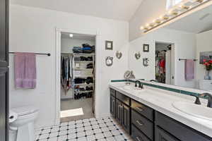 Bathroom featuring a walk in closet, double vanity, and tile patterned floors