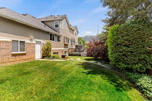 View of green lawn with a deck with mountain view