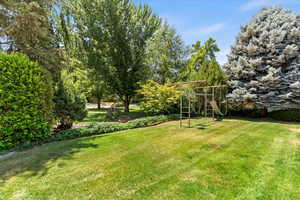 View of grassy yard featuring a playground