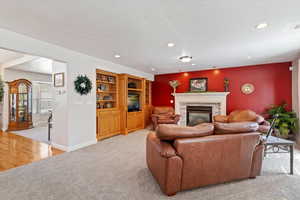 Living room with light carpet, a fireplace, and recessed lighting