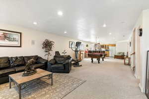Living room featuring pool table, light colored carpet, recessed lighting, and a textured ceiling