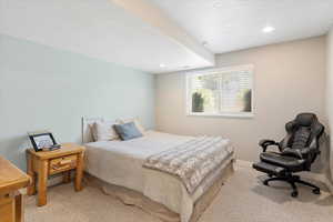 Bedroom featuring light colored carpet, a textured ceiling, and recessed lighting