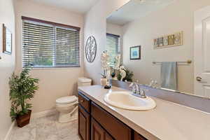 Bathroom featuring marble look tile flooring, vanity, and healthy amount of natural light