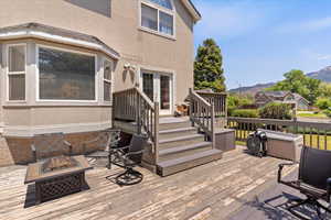 Wooden deck featuring a fire pit, a mountain view, and french doors