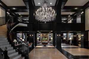 Lobby with a towering ceiling, stairs, coffered ceiling, and a decorative wall