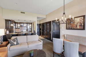 Carpeted living room featuring a chandelier and recessed lighting