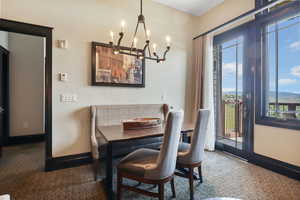 Dining space with plenty of natural light, a chandelier, and carpet flooring