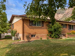 View of home's exterior with a yard, a mountain view, and brick siding