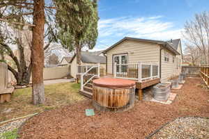 Back of house featuring a deck, a fenced backyard, and french doors
