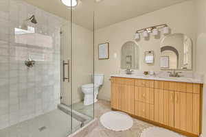 Bathroom featuring a stall shower, double vanity, and tile patterned flooring
