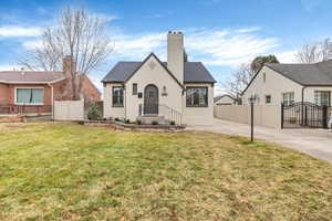 View of front of property featuring a gate, a chimney, and brick siding