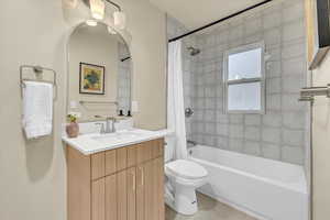 Full bathroom with vanity, shower / tub combo with curtain, and tile patterned flooring