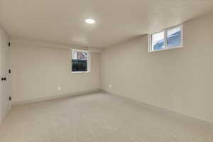 Basement with light carpet, healthy amount of natural light, and recessed lighting