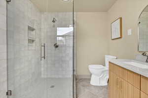Full bath with a stall shower, vanity, and tile patterned flooring