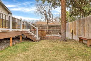 Fenced backyard featuring stairs and a deck