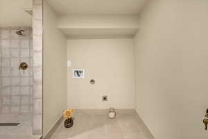 Washroom with electric dryer hookup, tile patterned flooring, and washer hookup