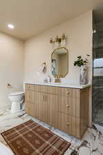 Full bathroom with marble finish flooring, vanity, a shower stall, and recessed lighting