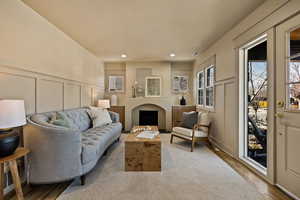 Living area with a decorative wall, wood finished floors, and recessed lighting