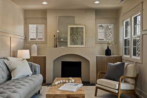 Living room with recessed lighting and a decorative wall
