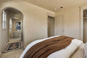 Bedroom featuring carpet and arched walkways