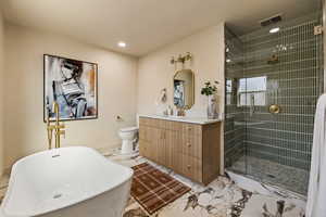 Full bathroom featuring marble finish flooring, vanity, a soaking tub, a stall shower, and recessed lighting