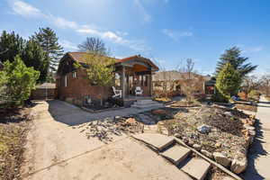 View of front of home featuring a tile roof, brick siding, and concrete driveway
