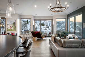 Living room with plenty of natural light, wood finished floors, lofted ceiling, and a chandelier