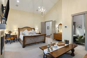 Bedroom with carpet flooring, high vaulted ceiling, and a chandelier