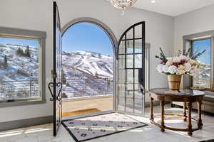 Doorway with marble look tile flooring, a mountain view, and healthy amount of natural light