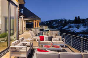 Snow covered patio featuring a balcony, a mountain view, and an outdoor living space
